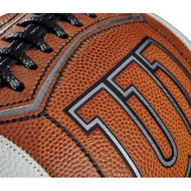 Close-up of Wilson GST Prime Football showing textured grip, black laces, and detailed stitching on brown pebbled surface